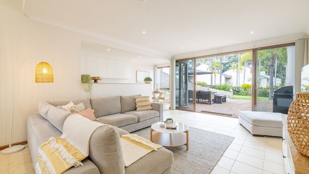 Una sala de estar moderna con un sofá, una mesa de centro y vistas al patio exterior.