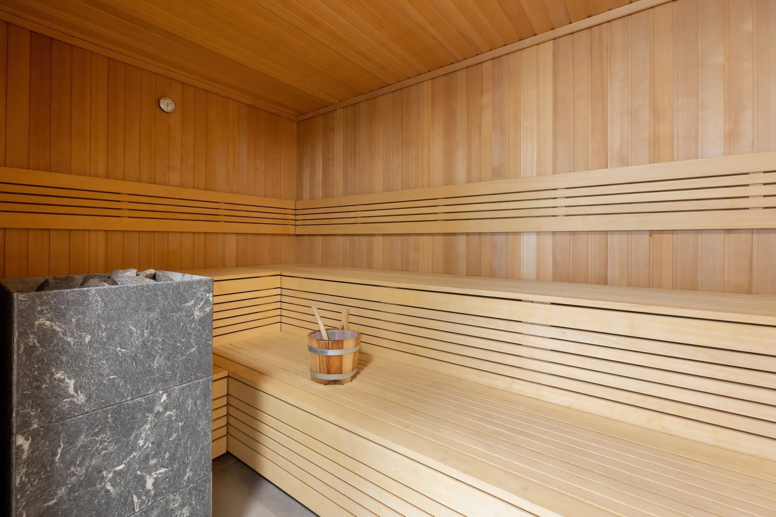 Un sauna avec des bancs en bois et un banc en marbre.