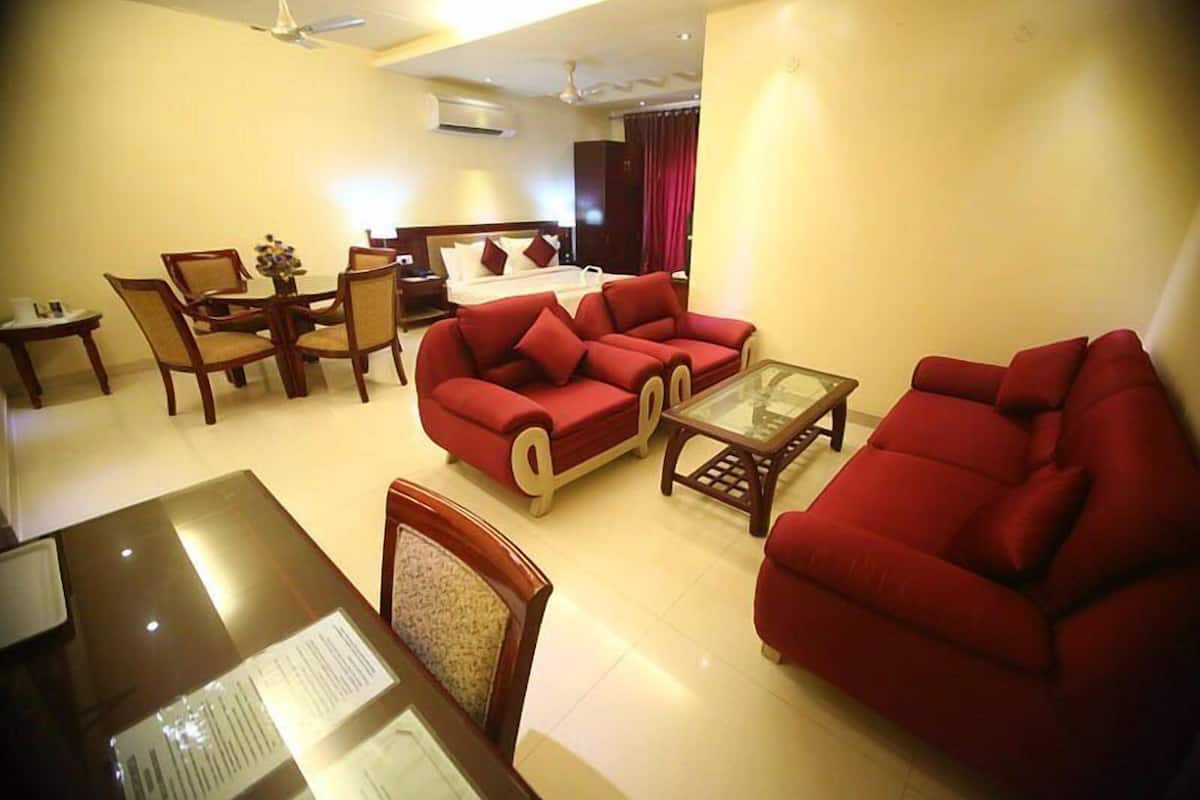 A modern living room with red sofas, a glass coffee table, and wooden furniture.