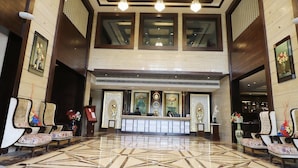 Un hall d’hôtel comprenant un comptoir d’accueil, un espace salon et des éléments décoratifs.
