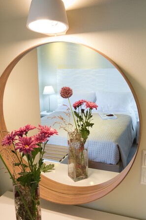 A mirror reflecting a bedroom with a bed, bedside table, lamp, and a vase with flowers. - Romantic Villa Gialos over Mikros Gialos (Fterno)