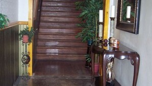 A polished wooden staircase leading to a hall with a sign reading "POLISH CADETS HALL ASSN 1912-1911".