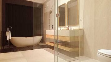 Ein modernes Badezimmer mit einer freistehenden Badewanne, einer in Glas eingefassten Duschkabine und einem WC.