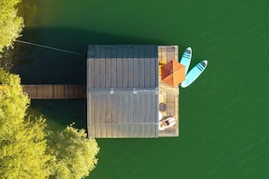 Un muelle de madera con dos tablas de surf y una sombrilla.