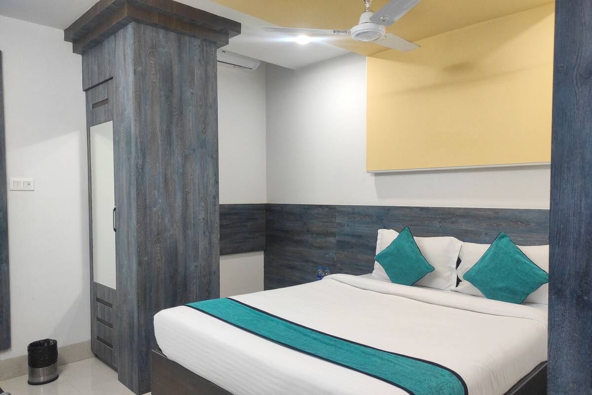 Ein Schlafzimmer mit Bett, Deckenventilator, Wandklimaanlage und Mülleimer.