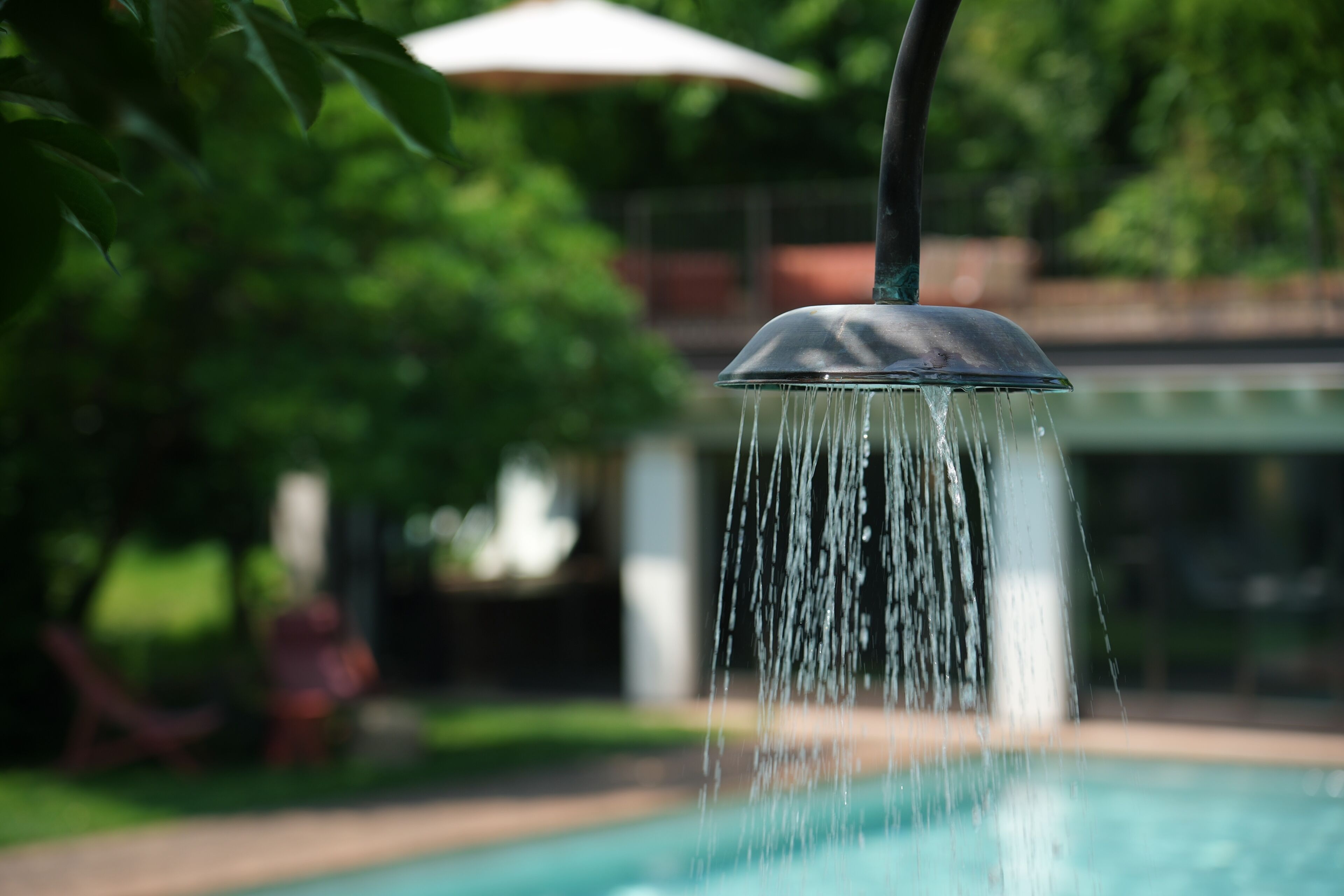 A water feature with a fountain in a landscaped area.