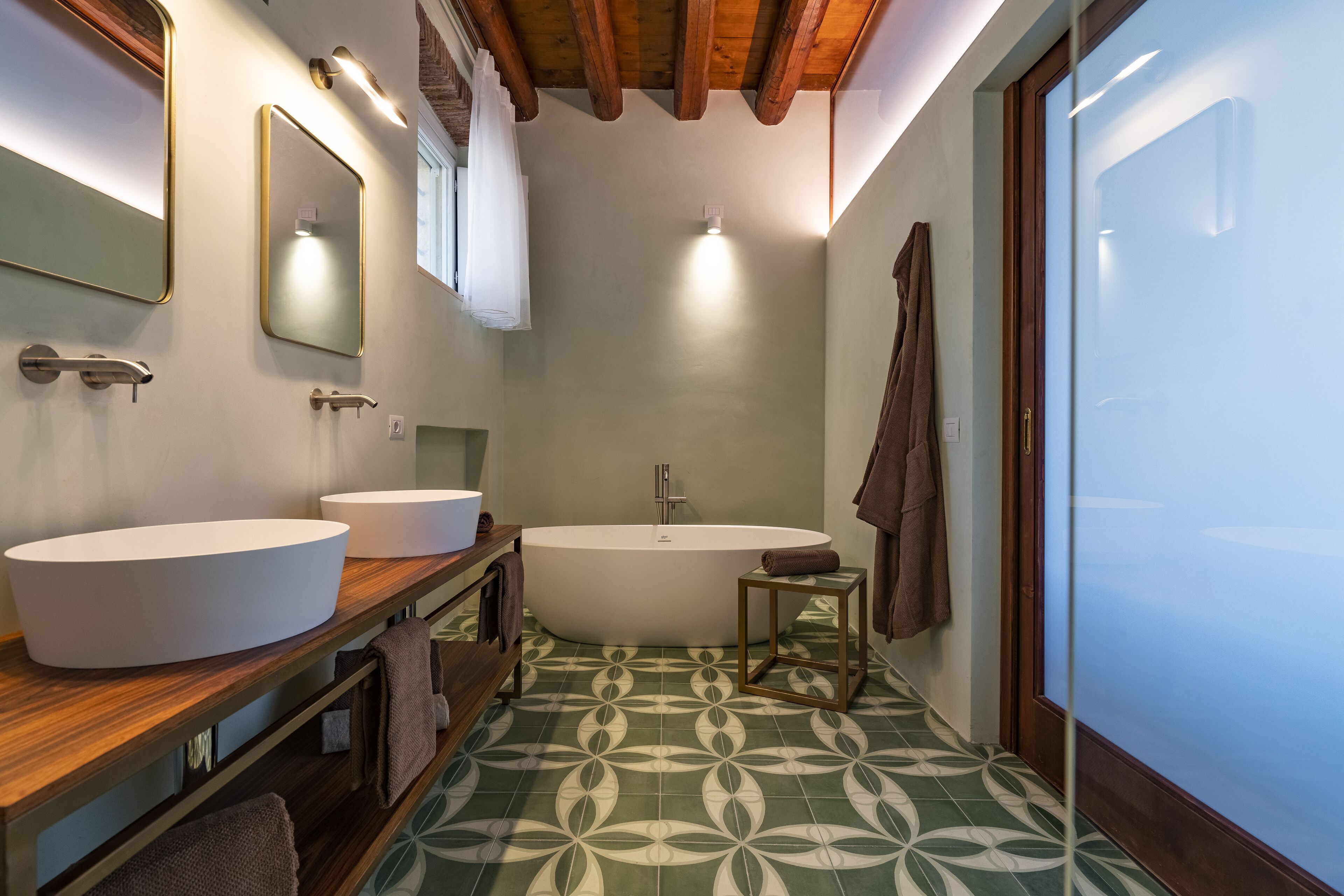 A bathroom with two sinks, a bathtub, and a mirror.