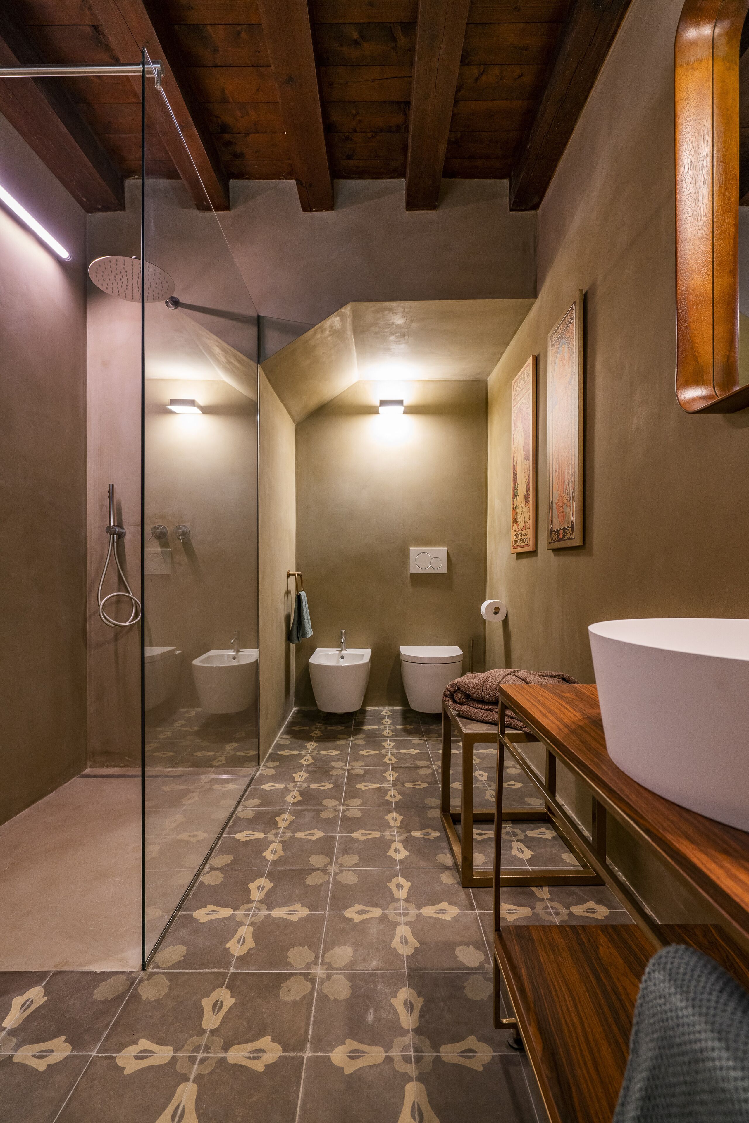 Un baño con ducha, dos lavamanos y un inodoro.