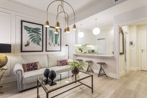 A modern living room with a sofa, coffee table, and pendant lights. - The Elegant Suite (GRANADA)