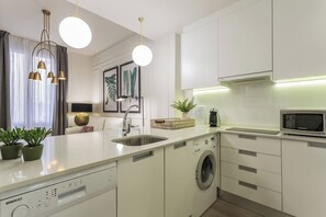 Eine moderne Küche mit Geschirrspüler, Waschmaschine und Mikrowelle.