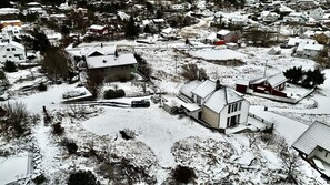 Een woonwijk met huizen, sommige met sneeuw op de daken en in de voortuinen.