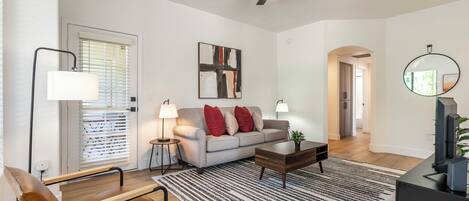 A modern living room with a sofa, coffee table, and floor lamp.