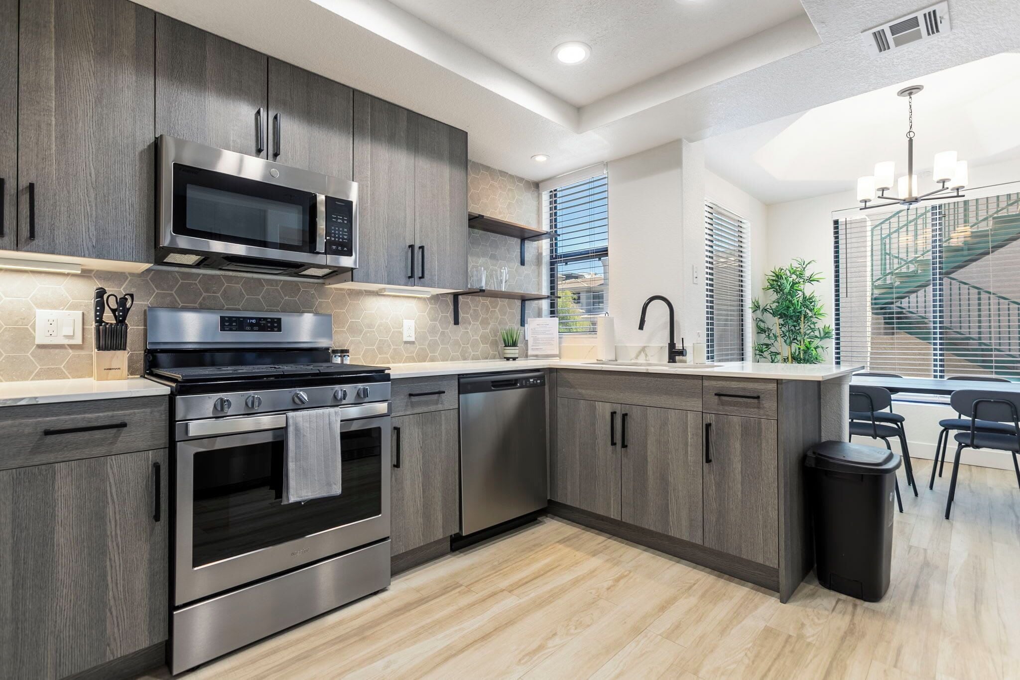 Una cocina moderna con electrodomésticos de acero inoxidable, armarios de madera y una isla central.