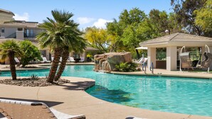 A pool area with lounge chairs, palm trees, and a gazebo. - CozySuites at Kierland Commons (Scottsdale)