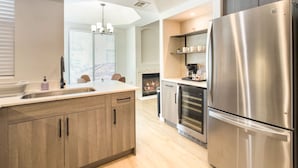 A modern kitchen with a central island, stainless steel appliances, and wooden cabinetry. - CozySuites at Kierland Commons (Scottsdale)