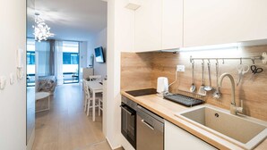 Una cocina moderna con encimera de madera, electrodomésticos de acero inoxidable y un lavamanos grande.