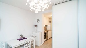 Una cocina moderna con armarios blancos, encimera de madera y horno empotrado.