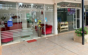 An 'APART HOTEL' with a glass facade, a red sofa, and a 'Vineteca' sign visible through the window. - EL TATA (Puerto Iguazú)