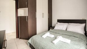 Een hotelkamer met een bed, een kledingkast en een nachtkastje.