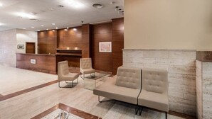 Un lobby moderno con una recepción, zona de estar y una chimenea.
