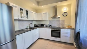 A modern kitchen with white cabinets, stainless steel appliances, and a built-in oven. - LO STELLARIO DI LUCCA in the historic center, parking very close, WiFi (Lucca)