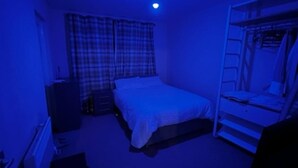 A room with a bunk bed, a single bed, a desk, and a chair.