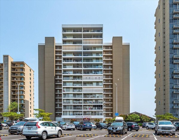 Un edificio de varios pisos con un diseño moderno, que cuenta con balcones en cada planta.