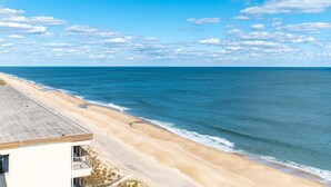 Une vue sur la plage avec un bâtiment situé à côté du rivage.