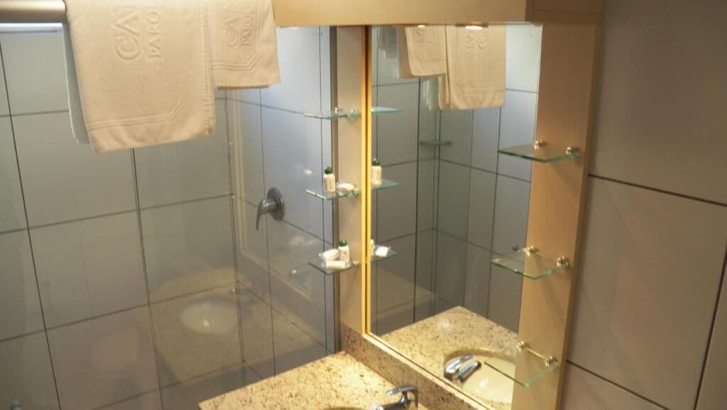 Une salle de bain moderne avec une douche à parois de verre, un grand miroir et un comptoir en granit.