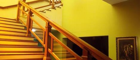 A staircase with wooden railings and a chandelier.