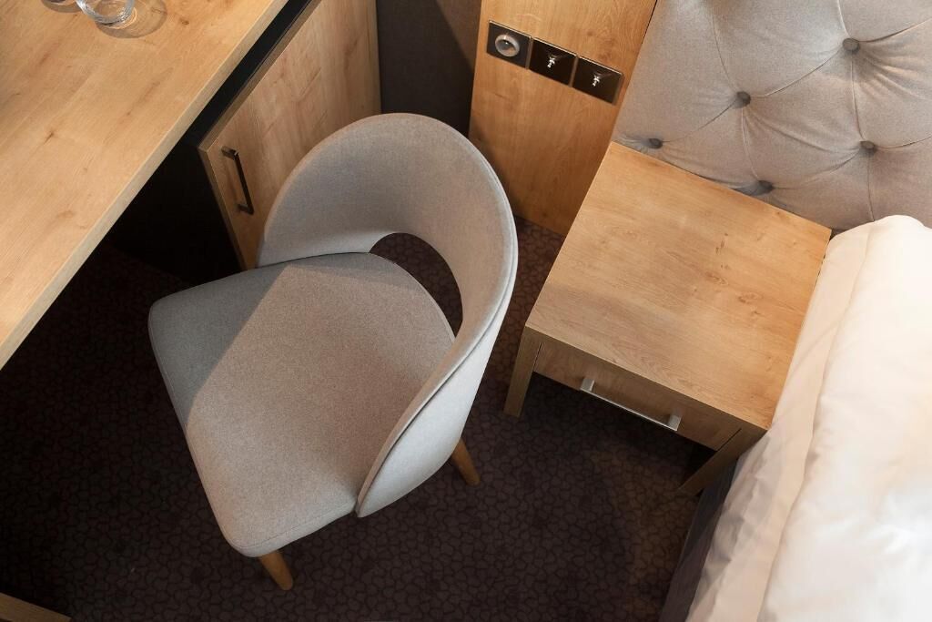 A compact room with a bed, a small desk, and a chair.