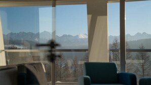 Una habitación con amplios ventanales y vistas a la montaña.