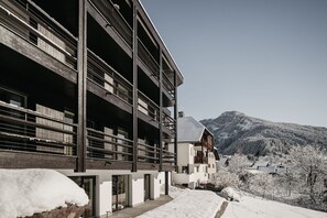 A modern building with multiple balconies, large windows, and a view of snow-covered mountains. - Apartment "Niuasi Dolomites Panorama" with Mountain View, Balcony and Wi-Fi (Ortisei)