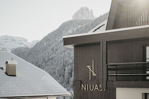 A modern building with a wooden facade and a logo that reads 'NIUAS.'