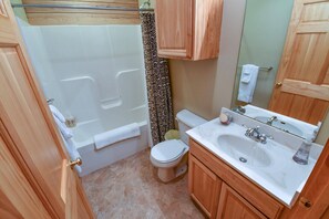 Een badkamer met een bad, toilet en wastafel.