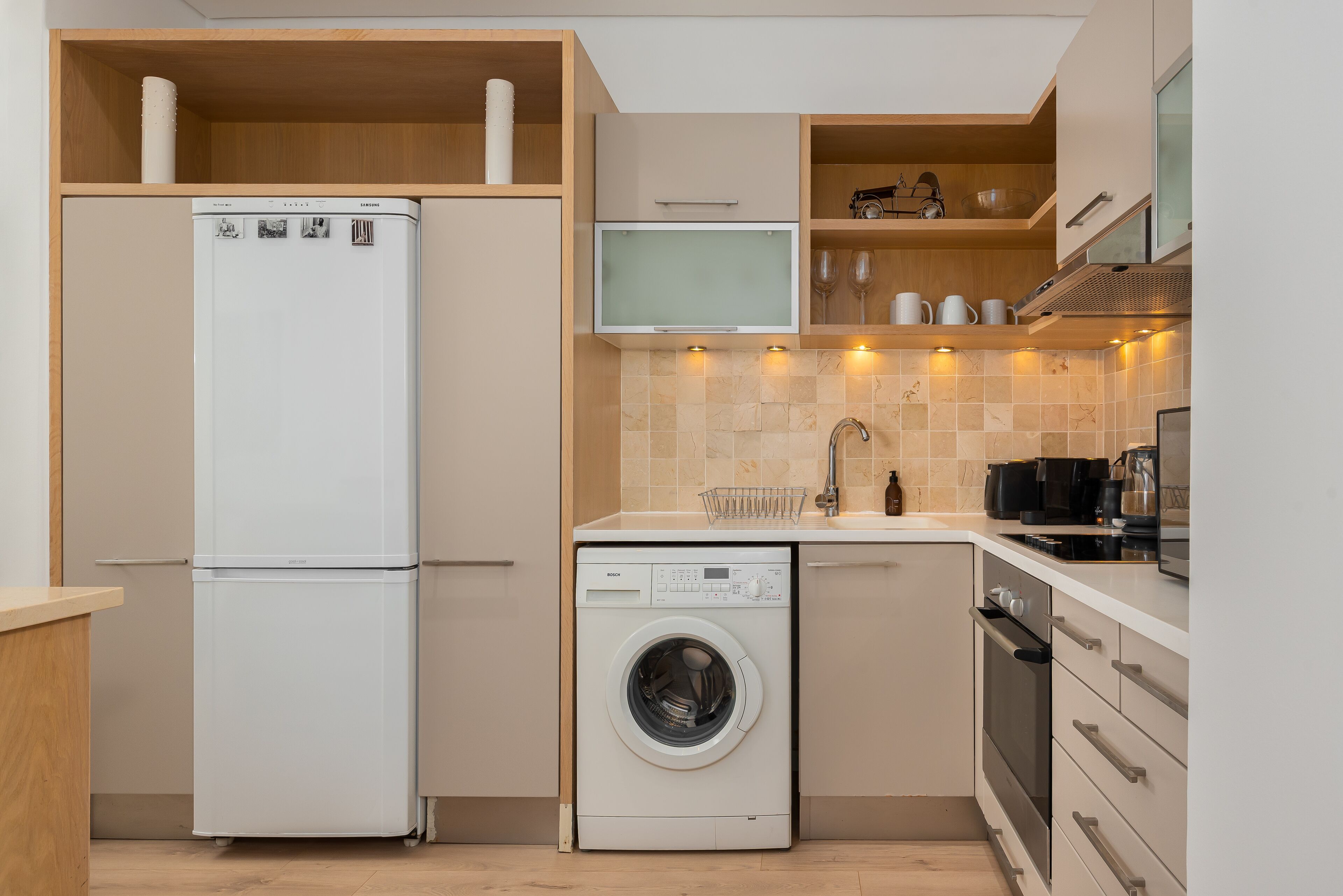 Una cocina compacta con lavadora integrada, microondas y estufa.