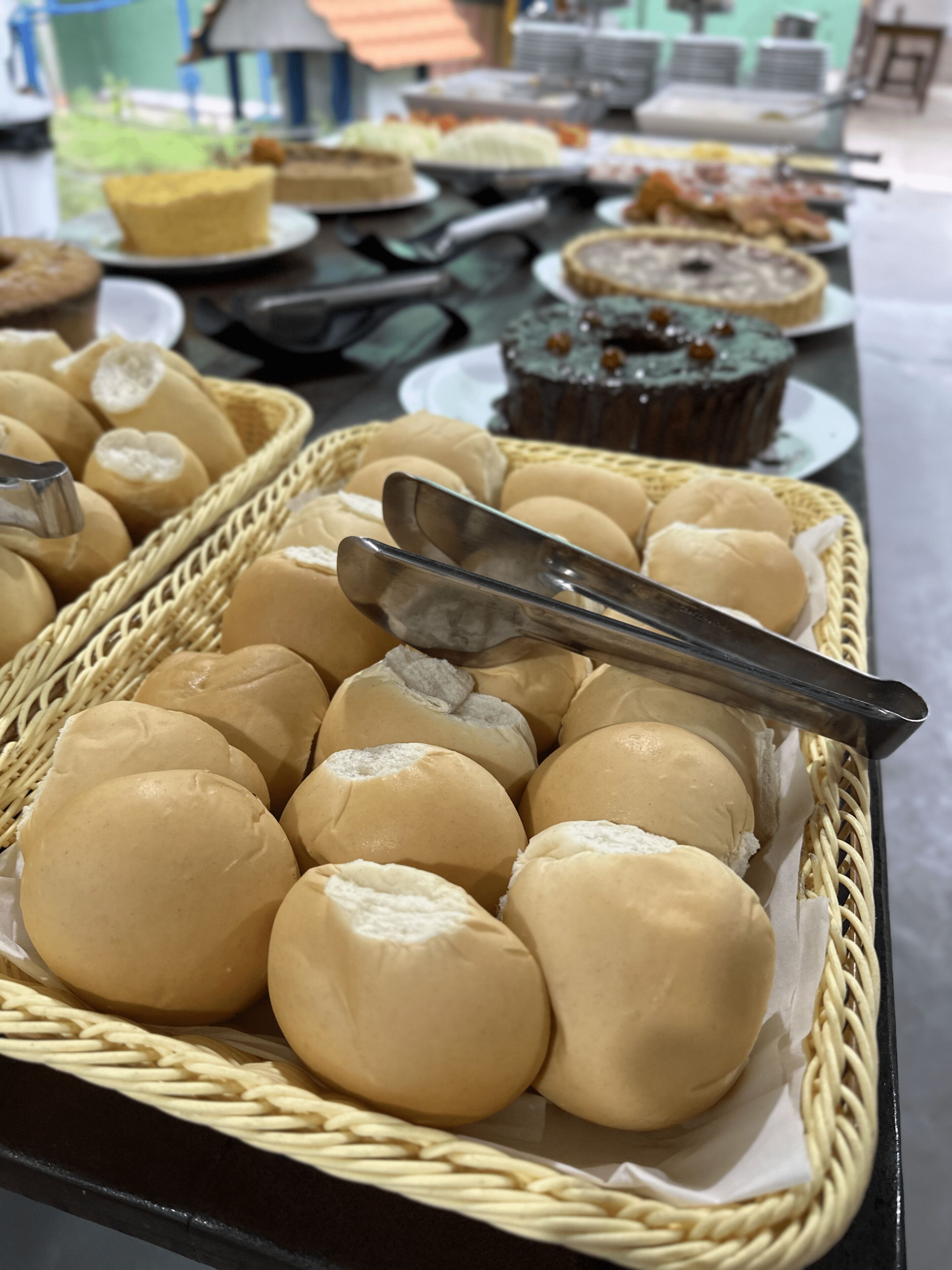 A buffet table with various food items including bread rolls and desserts.