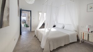 A bedroom with a canopy bed, a bedside table with a lamp, and a view of a hallway. - Villa Ambretta with Private Swimming Pool, Garden and Barbecue (Campagnatico)
