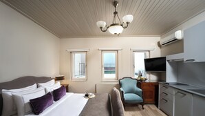 Une chambre d’hôtel avec un lit, un bureau, une chaise, une télévision et une fenêtre.