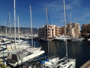 A marina with multiple boats docked, surrounded by buildings.