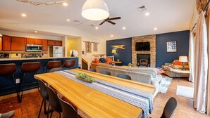Una cocina moderna con armarios de madera y un comedor con mesa y sillas de madera.