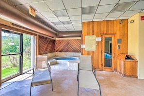 Una sala de sauna con pared de madera, un jacuzzi y un cartel que detalla las normas de la sauna.