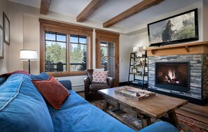 A cozy living room with a fireplace, a large TV, and a comfortable seating area.