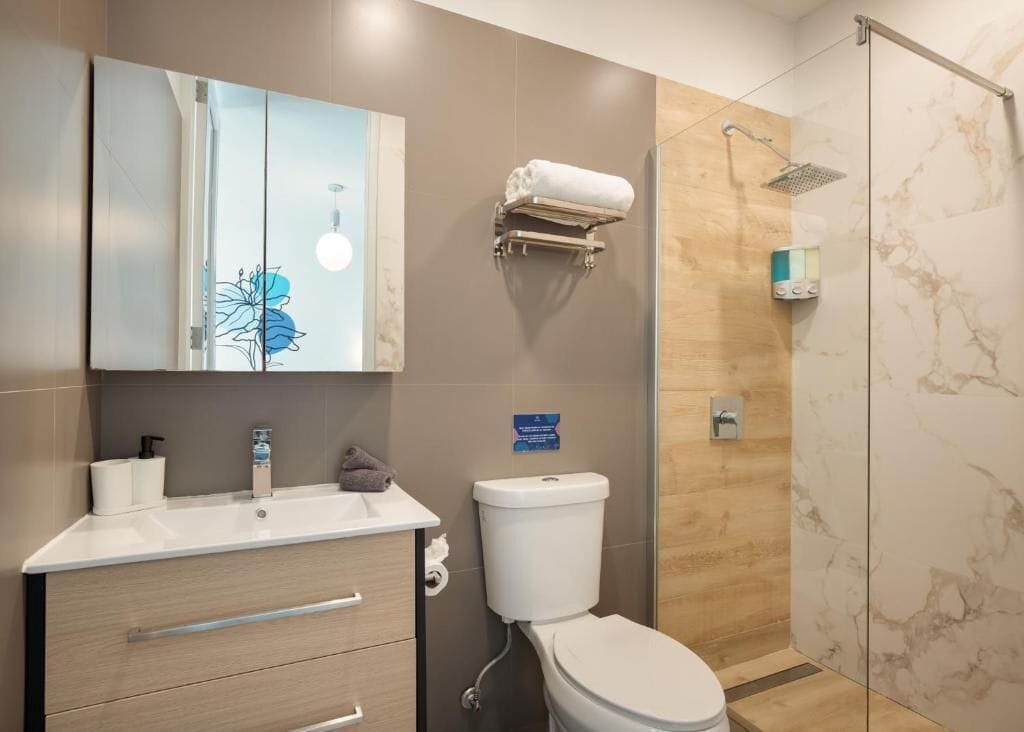 Un bagno moderno con WC, lavandino e doccia.