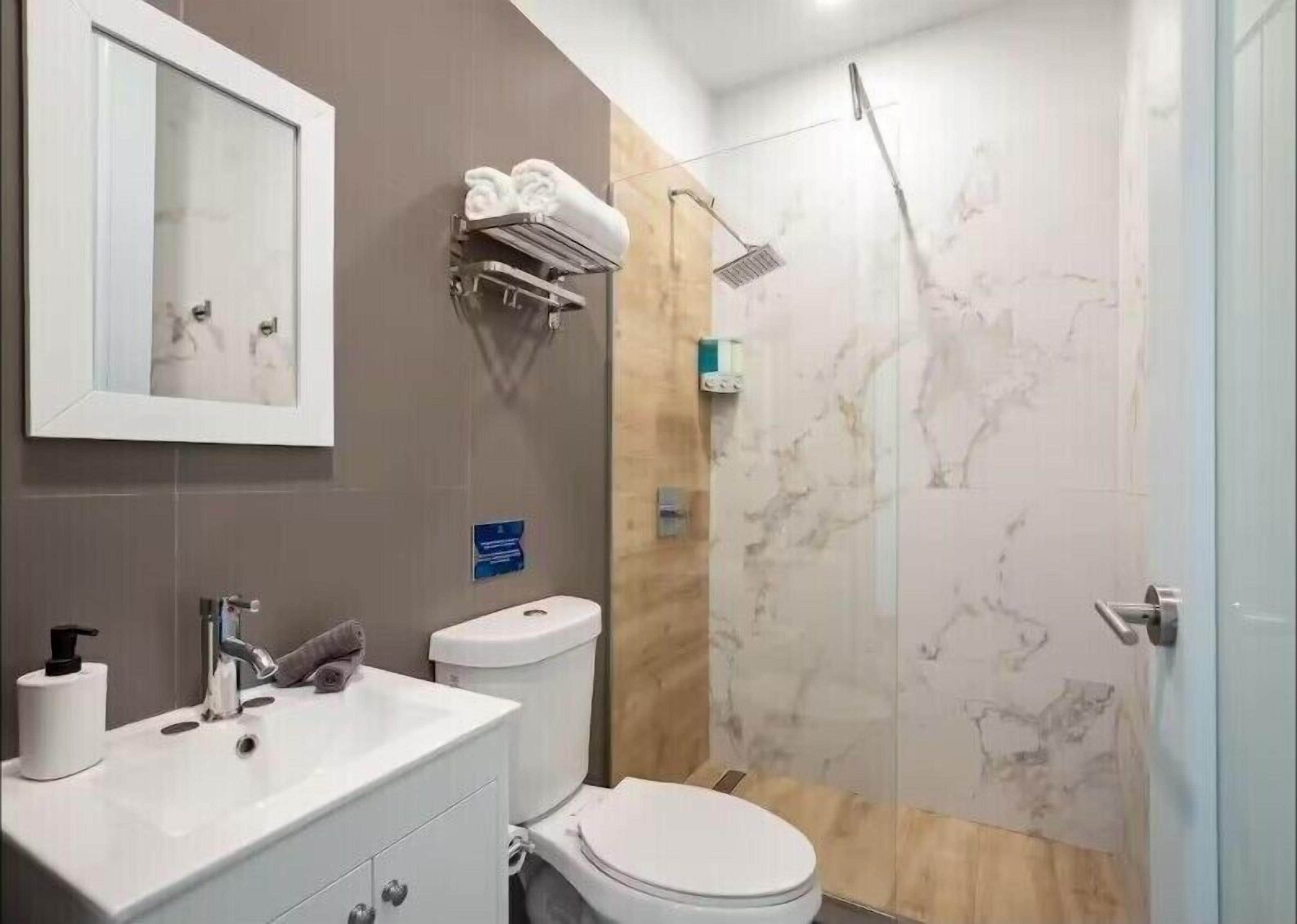 Une salle de bain moderne avec un lavabo, des toilettes et une douche.