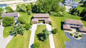 An aerial view of a residential area with a central building surrounded by well-maintained lawns and trees. - Spacious multi-unit retreat in Rockford (Rockford)
