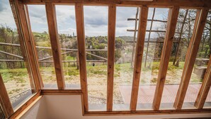 Una habitación con ventanas amplias que ofrecen vistas a un jardín ajardinado.