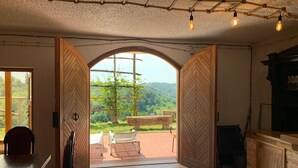 Una habitación con un amplio arco de entrada que da a un área exterior con un banco y sillas.