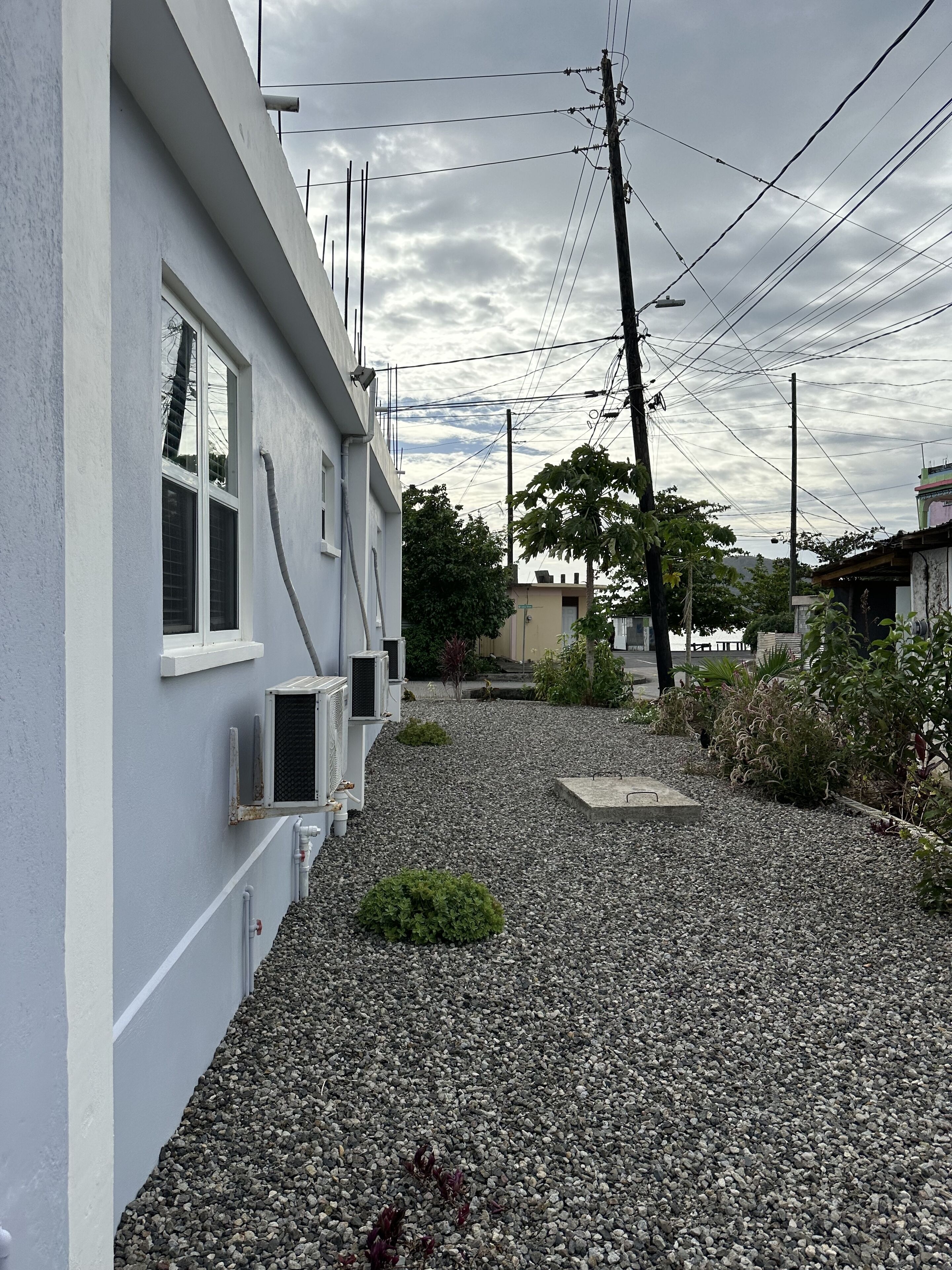 A residential building with a gravel driveway and a small garden area.