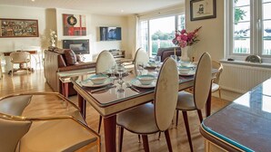 A dining area with a wooden table set for six, surrounded by six chairs.